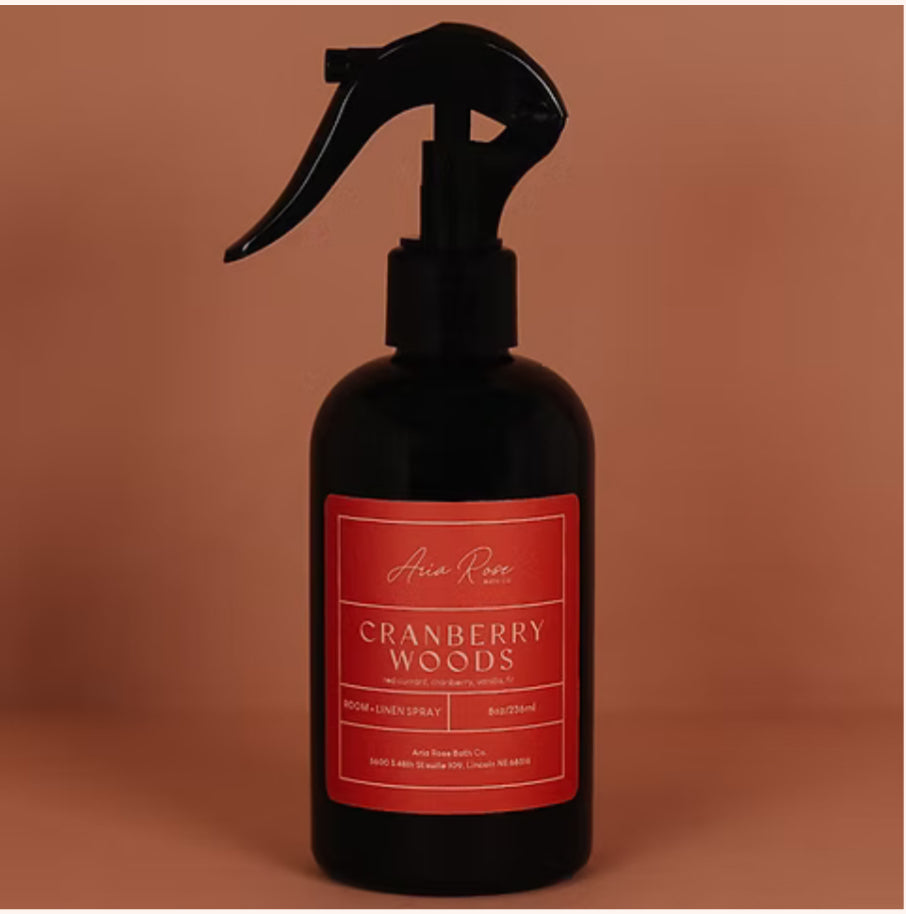 Black spray bottle with a red label on a brown background