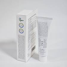 White tube and box with text on a light gray background