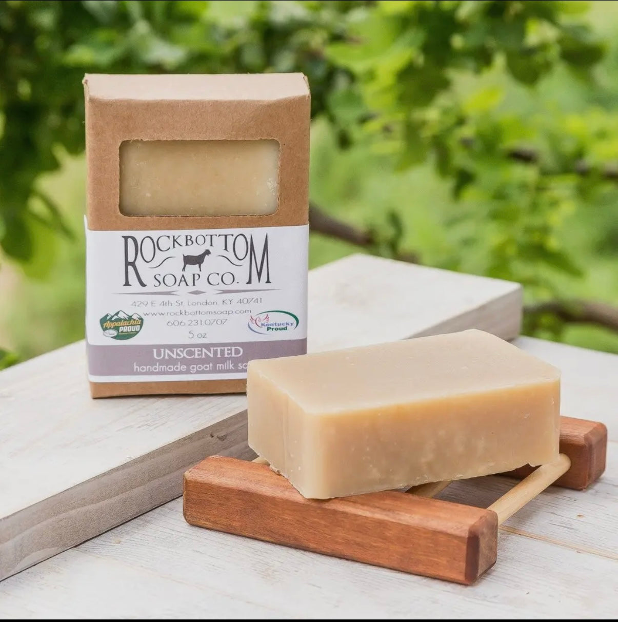 Bar of soap on a wooden stand with Rockbottom Soap Co. packaging in the background